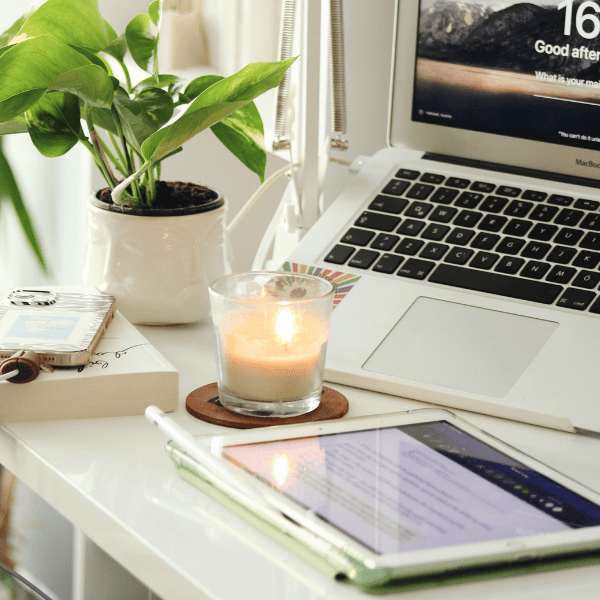 Reviewing a client offboarding process on a mounted laptop with a lit candle